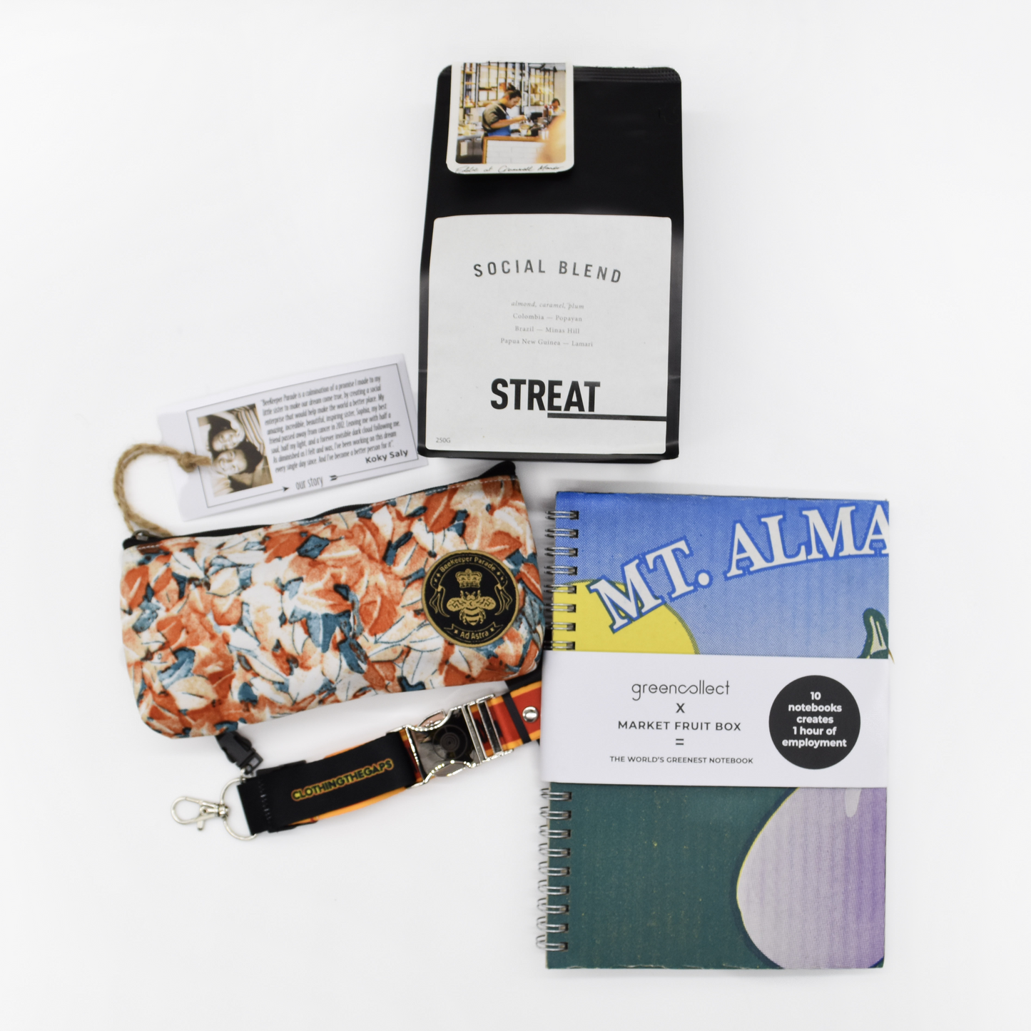 Collection of a notebook, a pouch, a bag of coffee and a keychain on a white background